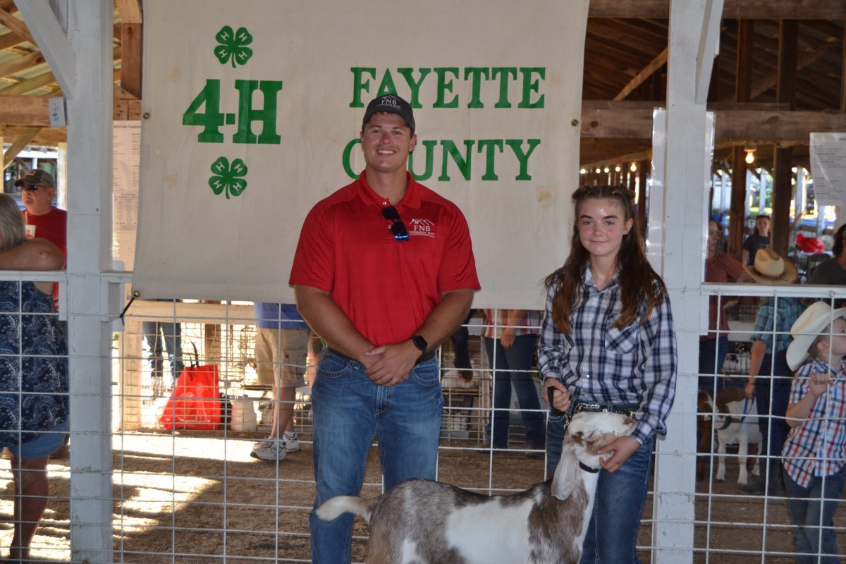 an F N B Community Bank employee posing for a photo with a county fair contestant