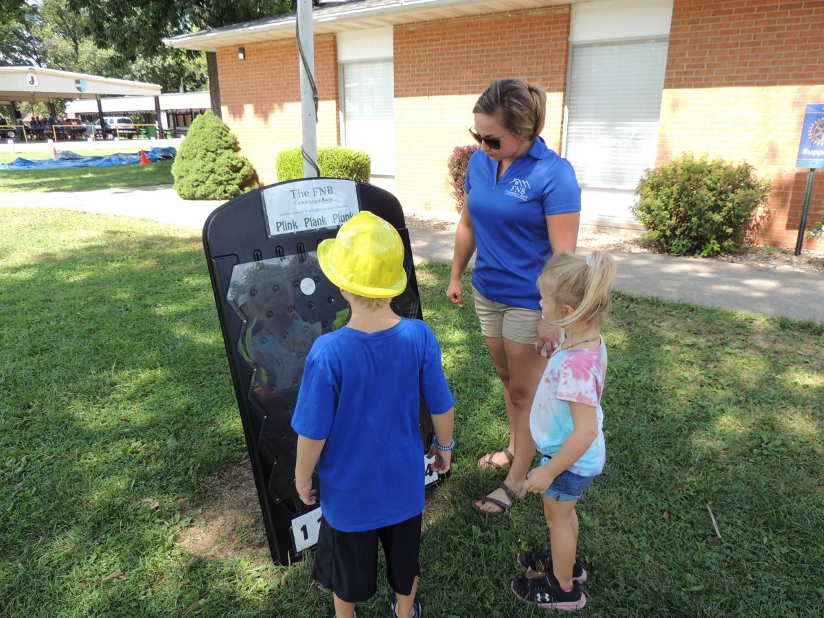an F N B Community Bank employee taking children on a tour at a local park