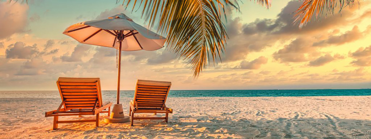 beach chairs and an umbrella on a beach viewing the ocean